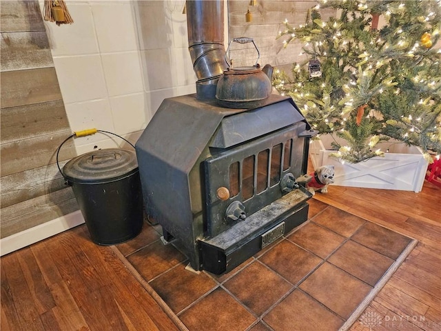 details featuring a wood stove and wood-type flooring