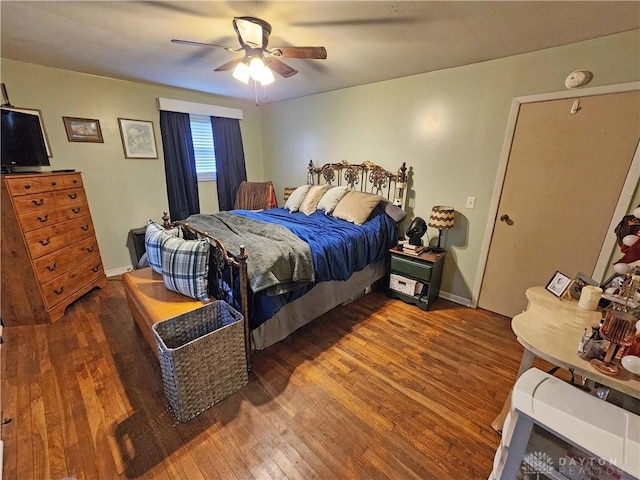 bedroom with dark hardwood / wood-style flooring and ceiling fan