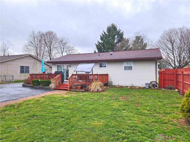 back of house with a lawn and a wooden deck