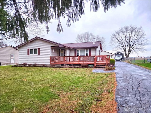 ranch-style home with a wooden deck and a front lawn