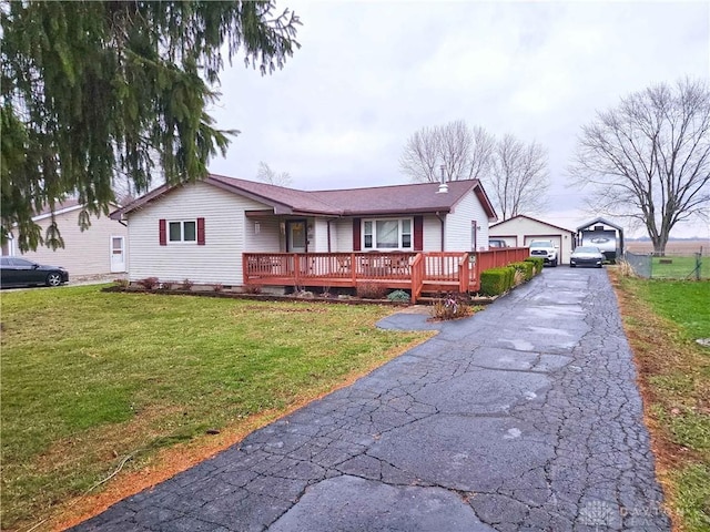 ranch-style house featuring a garage, a wooden deck, an outdoor structure, and a front lawn