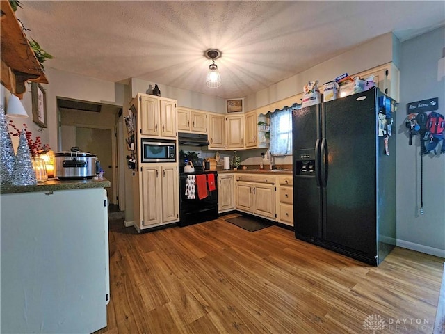 kitchen featuring sink, light hardwood / wood-style floors, a textured ceiling, black appliances, and exhaust hood