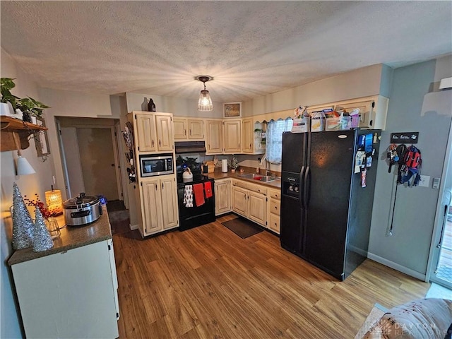 kitchen featuring light wood-type flooring, a textured ceiling, sink, black appliances, and range hood