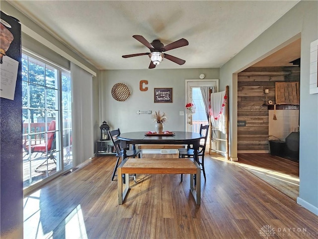 dining space featuring wood-type flooring and ceiling fan