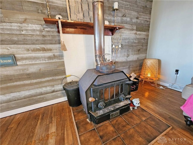 room details with wood-type flooring, wood walls, and a wood stove