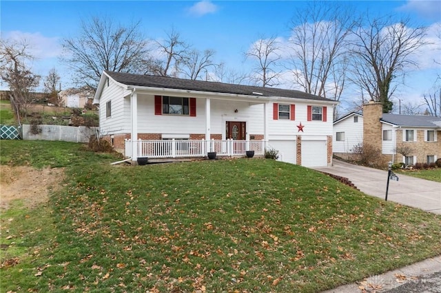 split foyer home featuring covered porch, a garage, and a front lawn