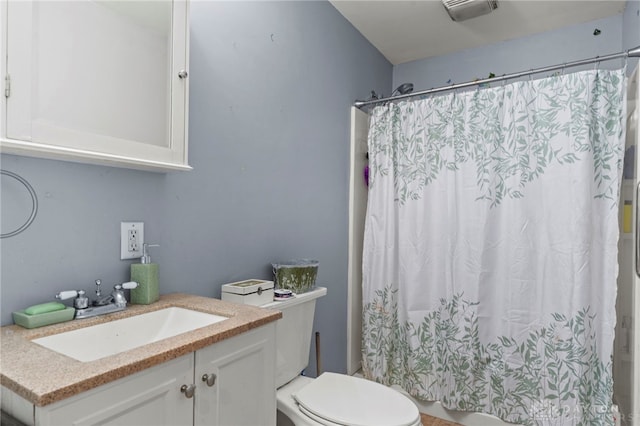 bathroom featuring vanity, toilet, and curtained shower