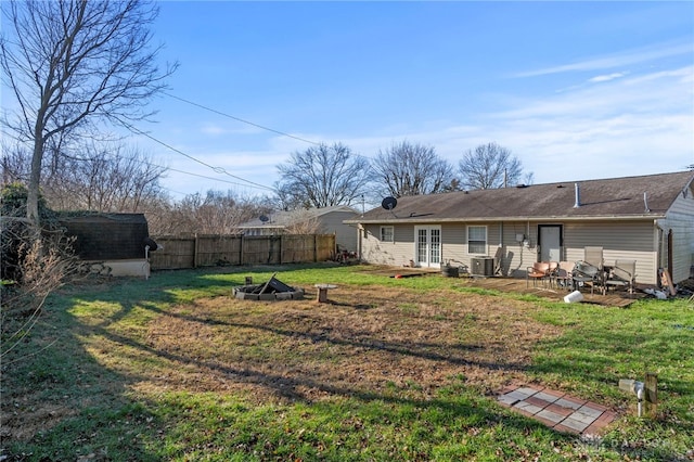 view of yard featuring central AC, french doors, a shed, and an outdoor fire pit