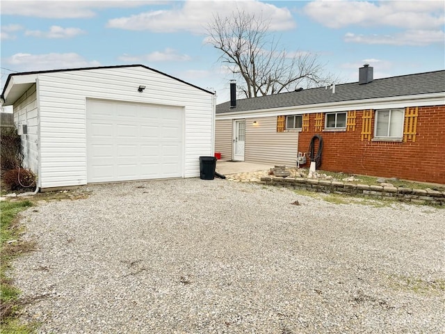 ranch-style house with a garage and an outbuilding