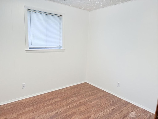 spare room featuring hardwood / wood-style floors and a textured ceiling