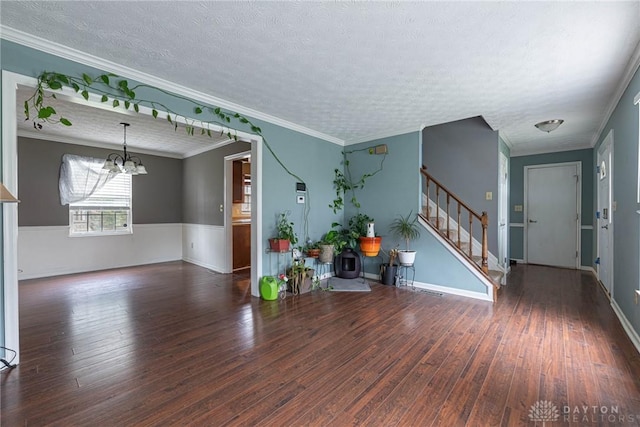 interior space featuring a textured ceiling, dark hardwood / wood-style flooring, crown molding, and an inviting chandelier