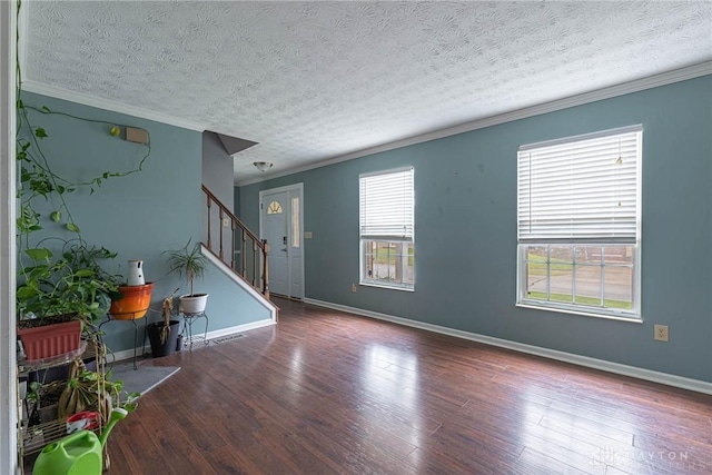 unfurnished room with a textured ceiling, dark hardwood / wood-style floors, and ornamental molding