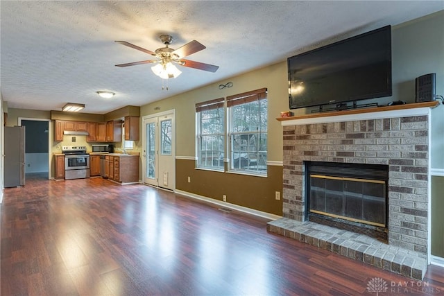 unfurnished living room with dark wood-style floors, a fireplace, a textured ceiling, and a sink