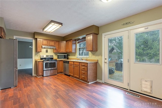 kitchen featuring dark hardwood / wood-style flooring, sink, a textured ceiling, and appliances with stainless steel finishes