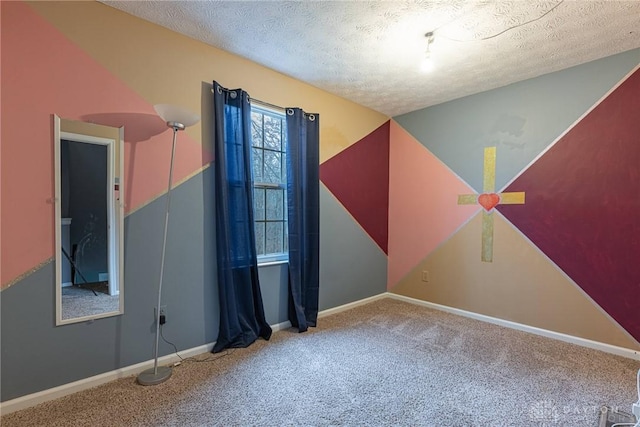 carpeted empty room featuring a textured ceiling