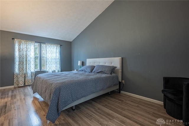 bedroom featuring wood-type flooring and vaulted ceiling