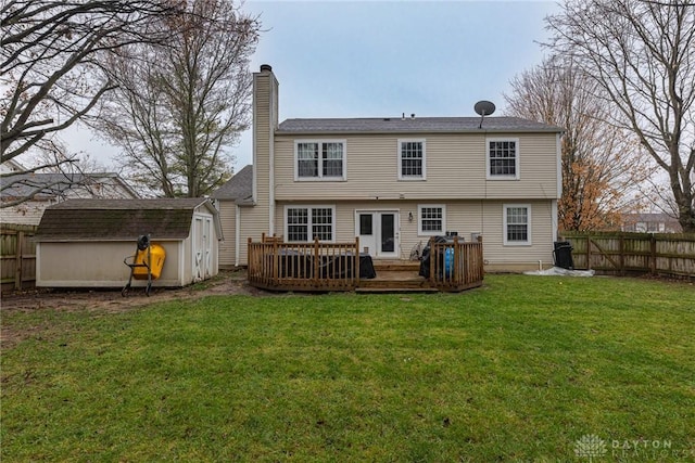 back of house with a shed, an outdoor structure, a fenced backyard, and a yard