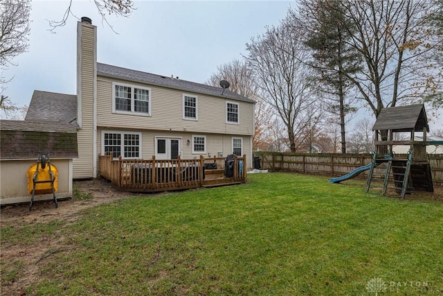 rear view of house featuring a playground, a lawn, and a wooden deck