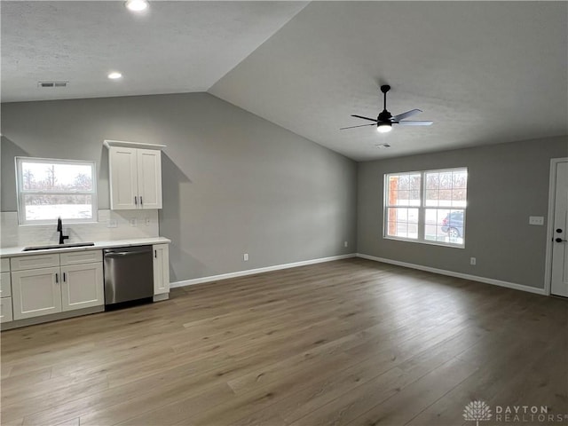 kitchen featuring sink, backsplash, white cabinets, and stainless steel dishwasher