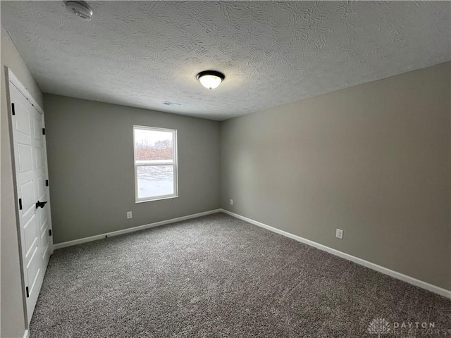 carpeted spare room with a textured ceiling