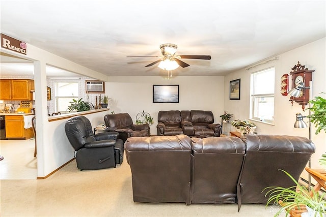 living room featuring light carpet, a wall mounted AC, and ceiling fan