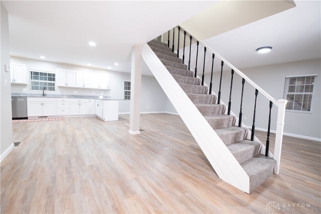 stairway featuring sink and wood-type flooring