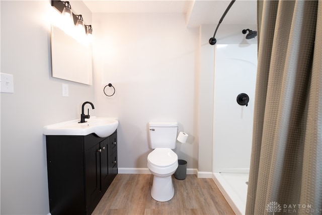 bathroom featuring vanity, curtained shower, toilet, and wood-type flooring