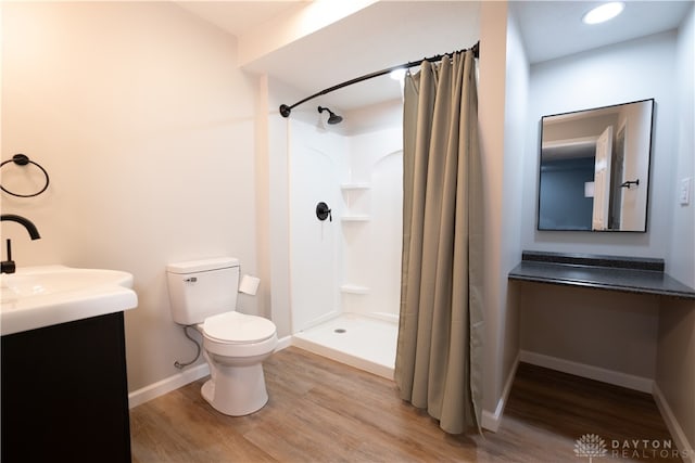 bathroom with toilet, wood-type flooring, vanity, and a shower with curtain