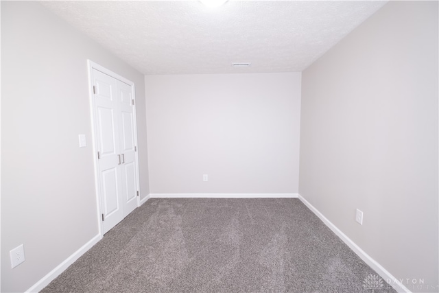 spare room featuring carpet and a textured ceiling