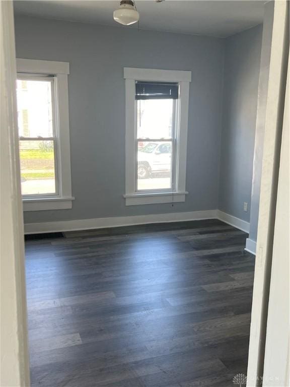 spare room with dark wood-type flooring