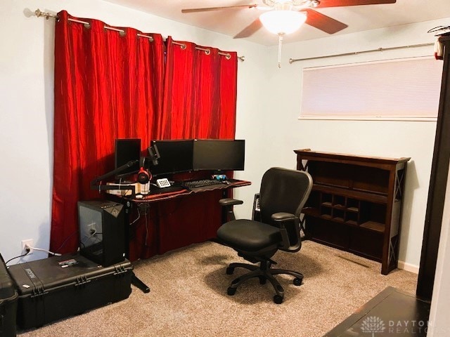 carpeted office space featuring ceiling fan