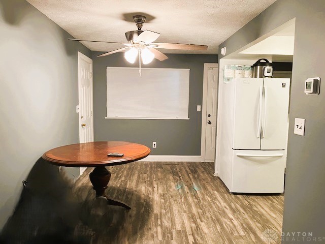 dining room with ceiling fan, wood-type flooring, and a textured ceiling