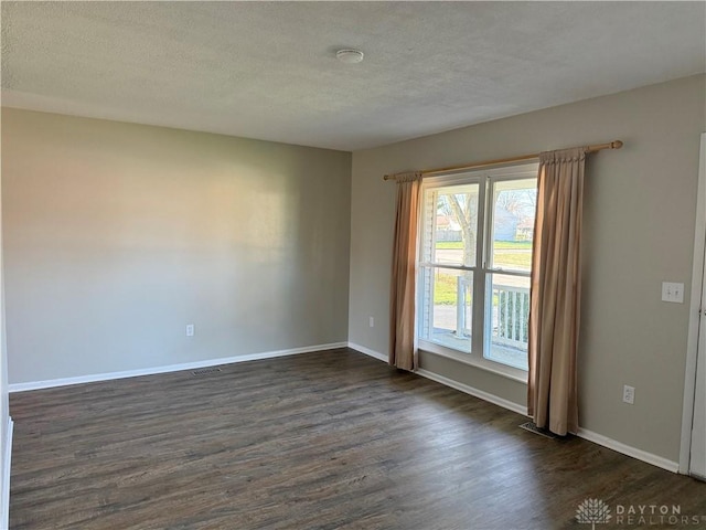 unfurnished room featuring a textured ceiling and dark wood-type flooring