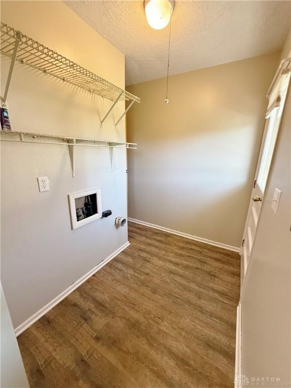 clothes washing area with a textured ceiling, dark wood-type flooring, and hookup for a washing machine