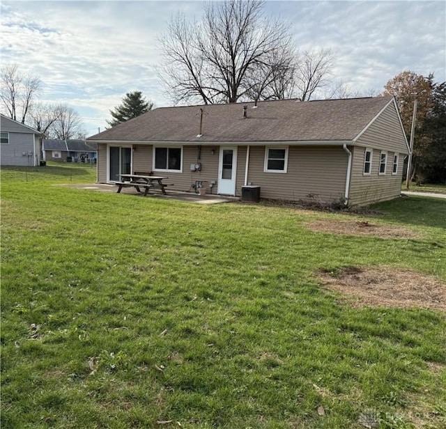 rear view of house with a patio, central air condition unit, and a lawn