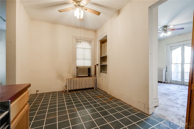 unfurnished room featuring radiator and ceiling fan