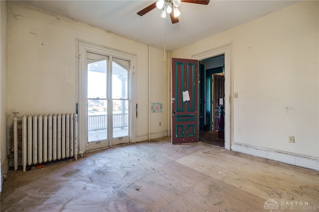 unfurnished room featuring ceiling fan and radiator