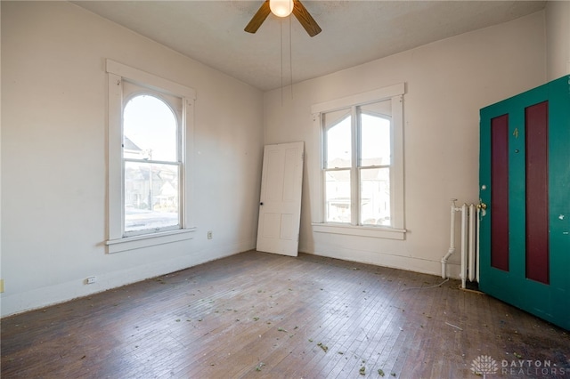 entrance foyer with hardwood / wood-style floors, ceiling fan, and radiator heating unit