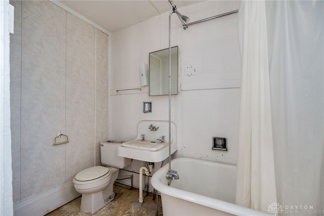 bathroom with a tub to relax in, toilet, and sink