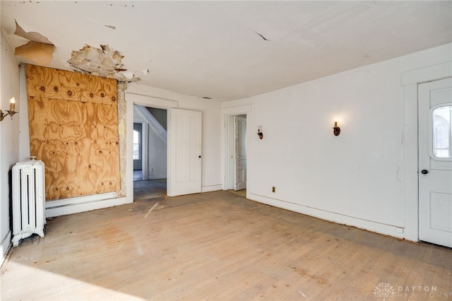 spare room with radiator heating unit and hardwood / wood-style flooring