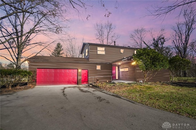 traditional-style home featuring aphalt driveway and an attached garage