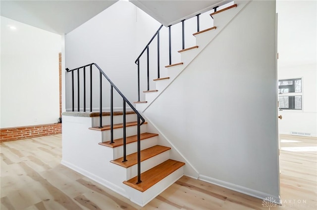 stairway with visible vents and wood finished floors
