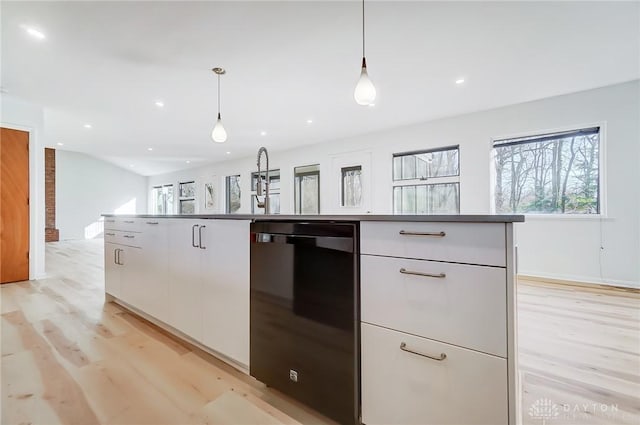 kitchen featuring dishwasher, light wood finished floors, white cabinetry, and hanging light fixtures