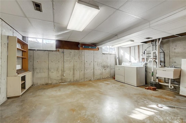 below grade area with separate washer and dryer, a sink, and visible vents