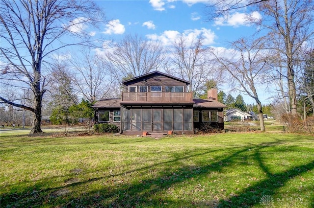 rear view of property featuring a lawn, a sunroom, and a chimney