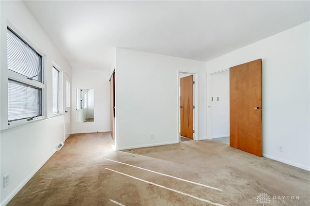 spare room featuring baseboards, visible vents, and carpet floors