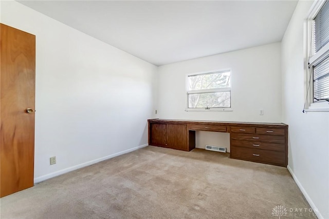 unfurnished office with baseboards, visible vents, and a wealth of natural light