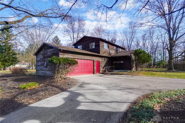 view of side of home with driveway and a garage