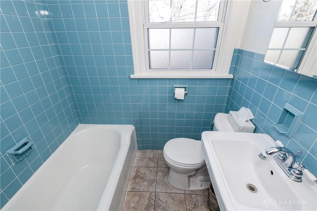 bathroom with toilet, sink, tile walls, and tile patterned flooring