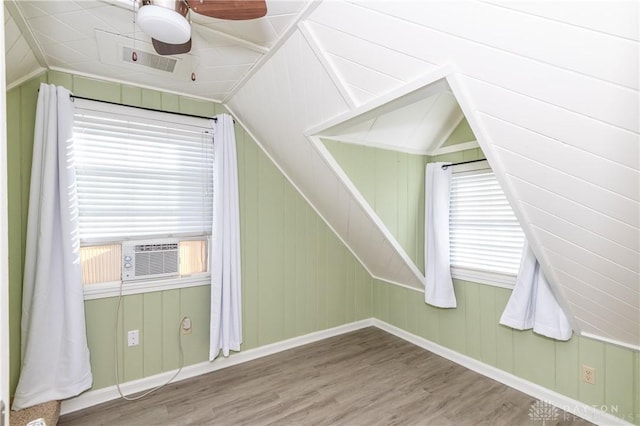 bonus room with hardwood / wood-style flooring, cooling unit, wooden walls, and vaulted ceiling